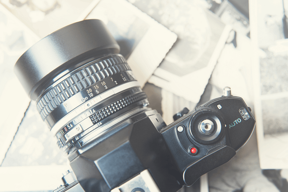 Picture of a camera with prints in promotion of the Hybrid Photography 5 class.